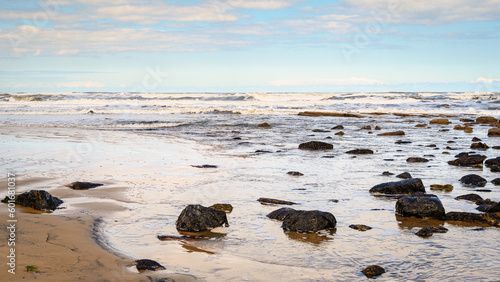 Rocks and Surf on Cambios Beach, located between the rivers Blyth and Wansbeck on the Northumberland coast and is a long stretch of sand backed by rocks and grassy dunes photo