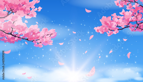 Pink sakura branches with petals falling against a bright blue sky with clouds. © Natalia