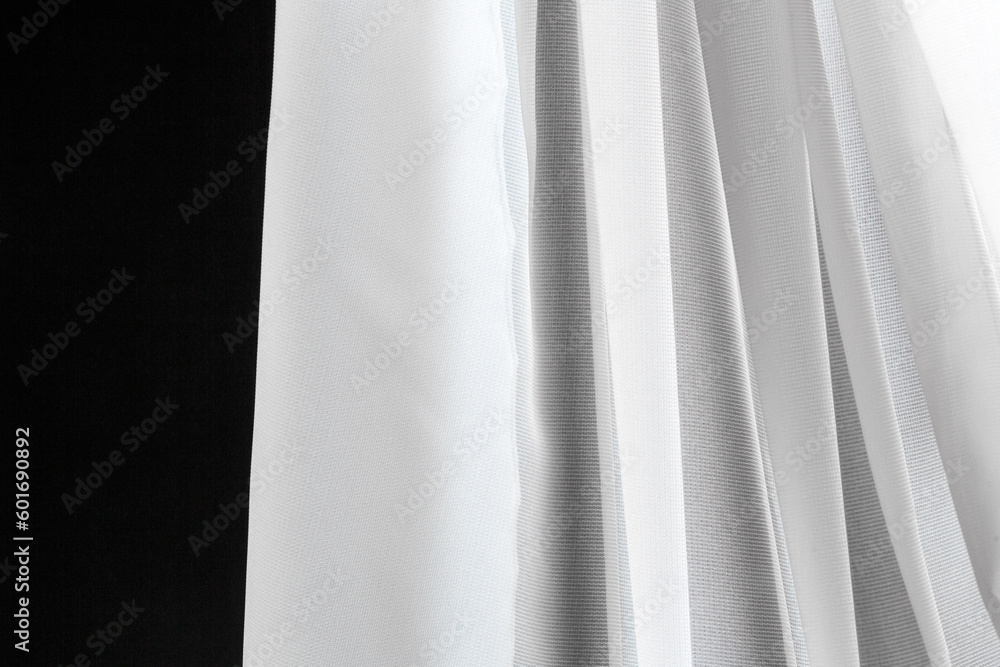 Folds of white transparent tulle textile on a white background. Folds of white transparent tulle textile on a white background.