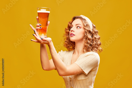 Canvas Print Young redhead girl, Oktoberfest waitress wearing vintage dress holding beer glass over yellow background