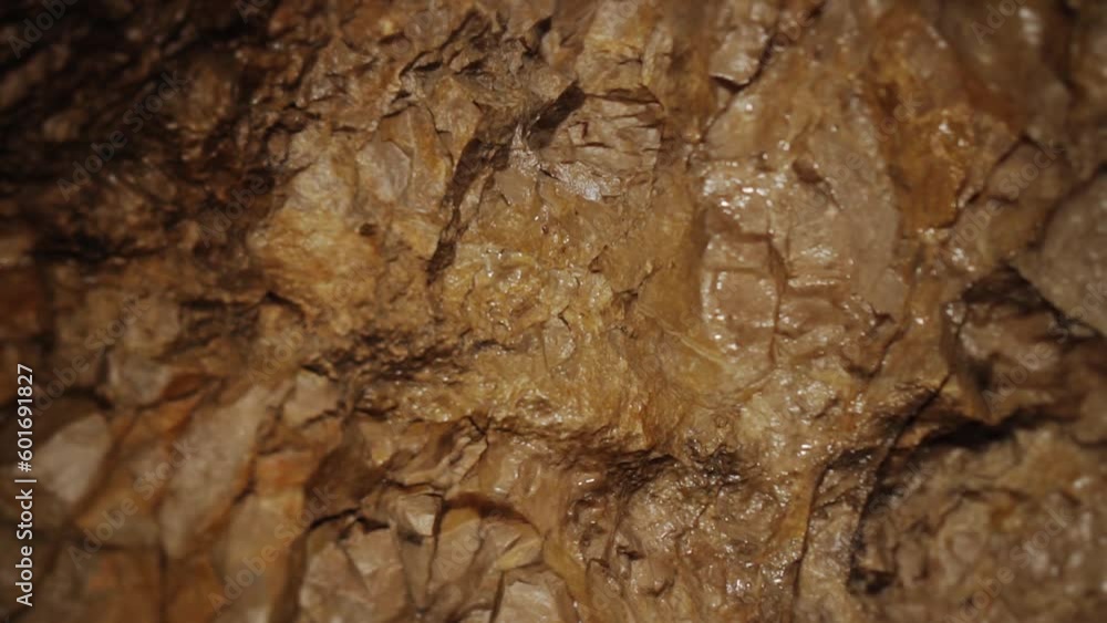 Wet rocky wall of narrow grungy corridor in picturesque cave Wet rocky wall of narrow grungy corridor in picturesque cave