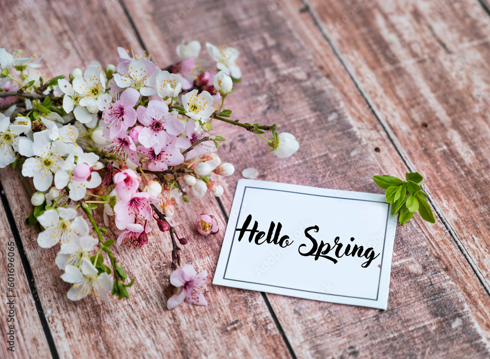 Cherry blossoms with hello spring text on a wooden background. Spring greeting card Cherry blossoms with hello spring text on a wooden background. Spring greeting card