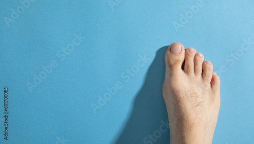 Male barefoot on the blue background.