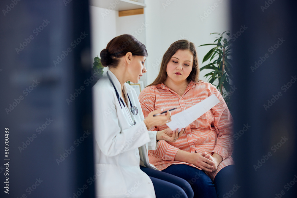 Fototapeta premium A female nutritionist explains a diet plan to a worried pretty curvy woman.