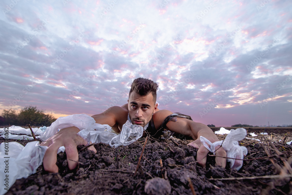 sports man with athletic figure wrapped in plastic on the ground at ...
