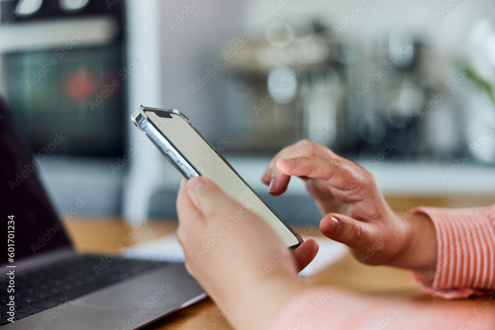 Side view of a woman using a smartphone with blank white screen, indoors. Side view of a woman using a smartphone with blank white screen, indoors.