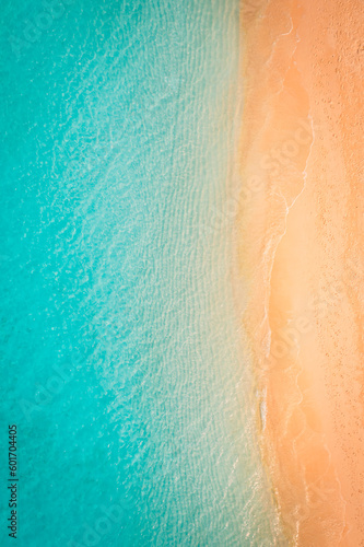 Top drone view travel landscape. Summer sunrise seascape waves, blue sea water yellow sand. Aerial amazing tropical nature background. Beautiful bright sea waves splashing and beach sand sunset light © icemanphotos