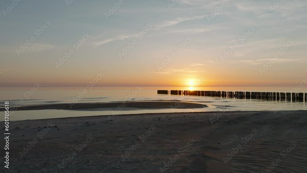 Establishing aerial view of Baltic sea coast, old wooden pier, calm evening with vibrant sunset, romantic golden hour light, white sand beach, wide drone dolly shot moving right low Establishing aerial view of Baltic sea coast, old wooden pier, calm evening with vibrant sunset, romantic golden hour light, white sand beach, wide drone dolly shot moving right low