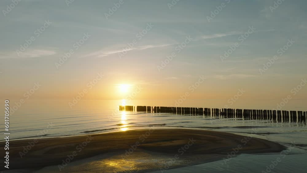 Establishing aerial view of Baltic sea coast, old wooden pier, calm evening with vibrant sunset, romantic golden hour light, white sand beach, wide drone shot moving forward low Establishing aerial view of Baltic sea coast, old wooden pier, calm evening with vibrant sunset, romantic golden hour light, white sand beach, wide drone shot moving forward low