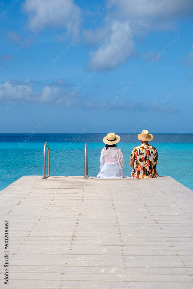 Men and women on the beach of Playa Porto Marie Beach in Curacao, a tropical beach on the Caribbean Island of Curacao. 