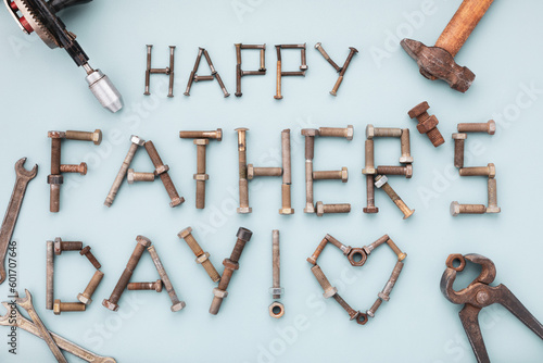 Fototapeta Naklejka Na Ścianę i Meble -  Happy fathers day greeting card with tools and lettering text from vintage screws top view on blue background.