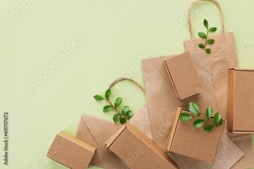 Eco, zero waste, plastic free and saving energy minimal concept from sprout with green leaves growing from recycled cardboard box and craft packages top view.