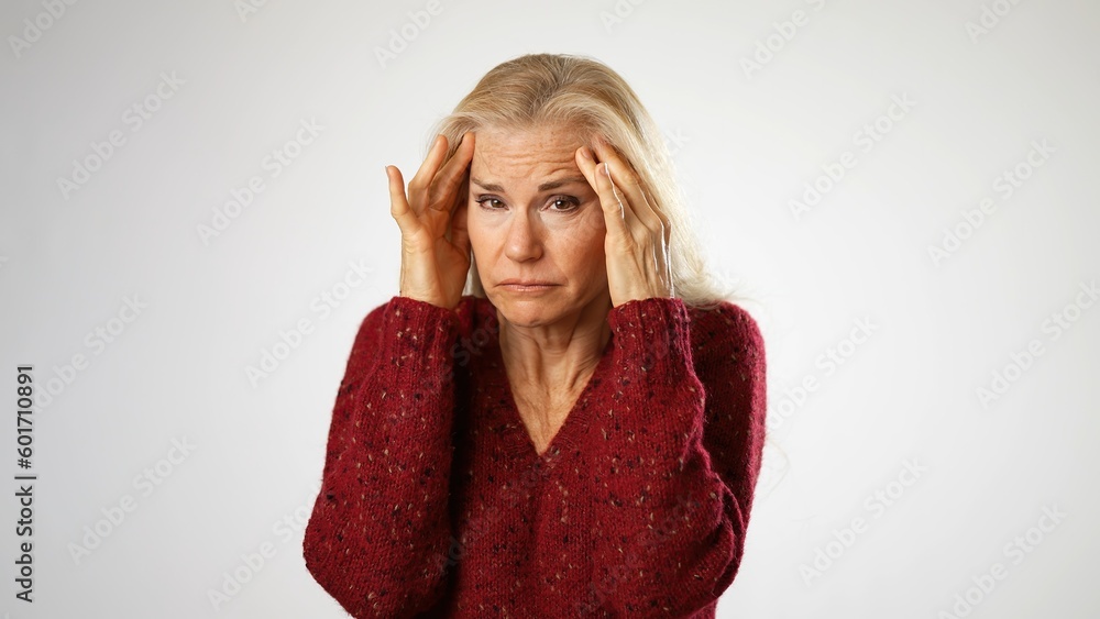 Portrait of tired depressed elderly mature woman 50s with migraine headache posing isolated on white background studio. Closeup people lifestyle concept. Put hands face temples Portrait of tired depressed elderly mature woman 50s with migraine headache posing isolated on white background studio. Closeup people lifestyle concept. Put hands face temples