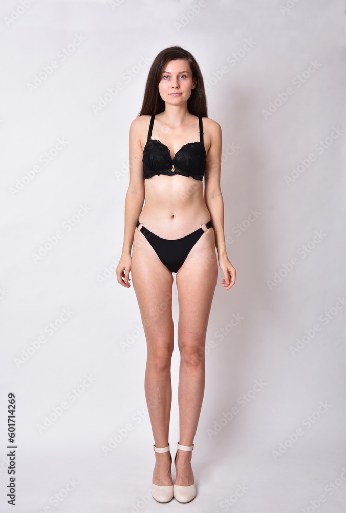 Young woman, brunette. Female model with black underwear, profile photo shoot.
