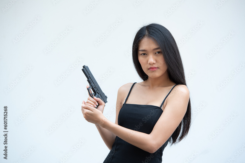 Sexy beauty young woman in black camisole posing with gun on white background. Girl in camisole with gun hand sexy brunette woman gun plain background. Sexy beauty young woman in black camisole posing with gun on white background. Girl in camisole with gun hand sexy brunette woman gun plain background.