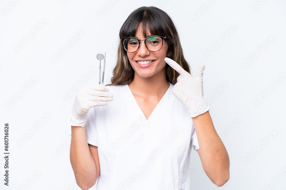Dentist caucasian woman holding tools isolated on white background giving a thumbs up gesture Dentist caucasian woman holding tools isolated on white background giving a thumbs up gesture