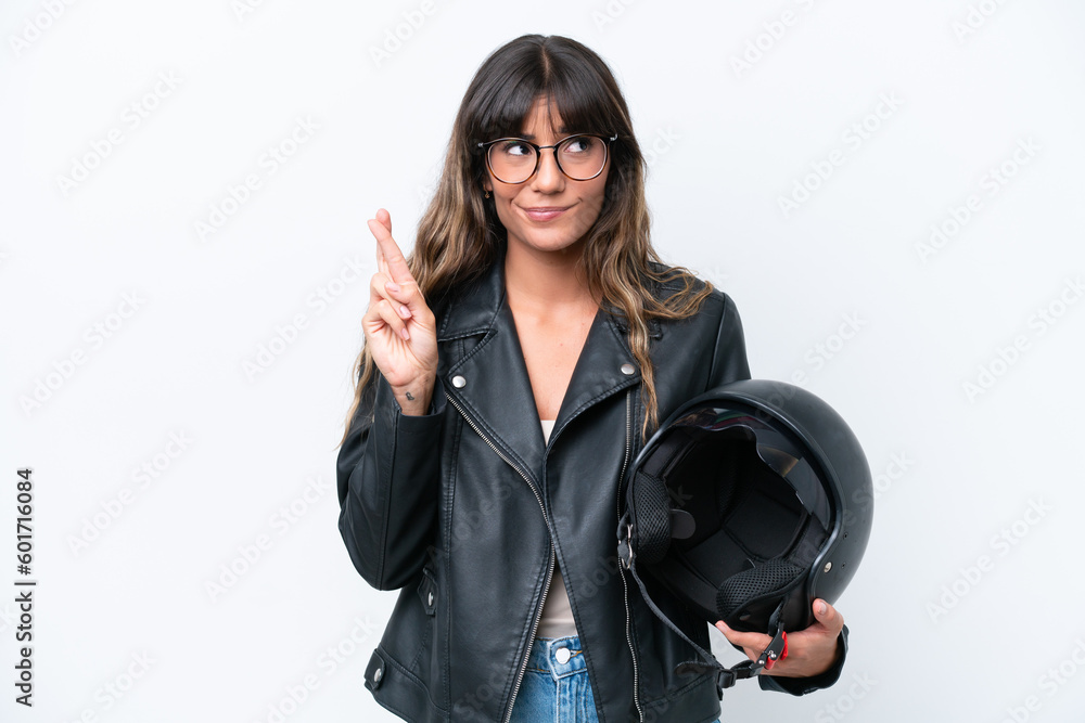 Young caucasian woman with a motorcycle helmet isolated on white background with fingers crossing and wishing the best Young caucasian woman with a motorcycle helmet isolated on white background with fingers crossing and wishing the best