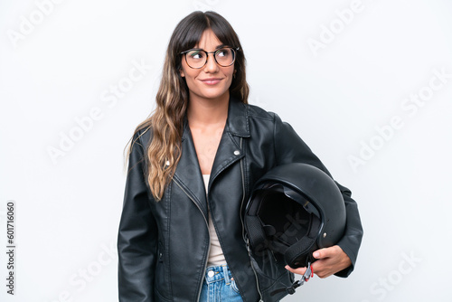 Young caucasian woman with a motorcycle helmet isolated on white background thinking an idea while looking up