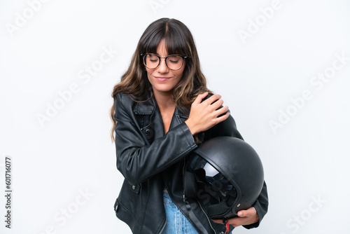 Young caucasian woman with a motorcycle helmet isolated on white background suffering from pain in shoulder for having made an effort