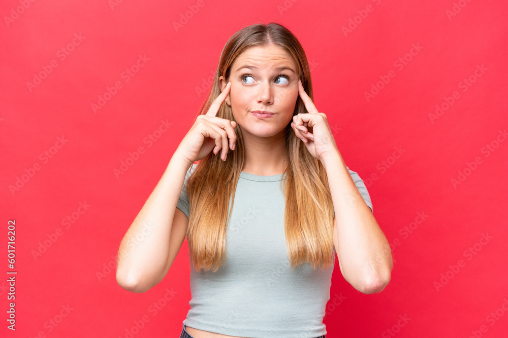 Fototapeta premium Young beautiful woman isolated on red background having doubts and thinking