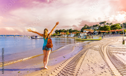 Happy woman enjoying beautiful sunset at the beach, coastline of Arcachon bay in France