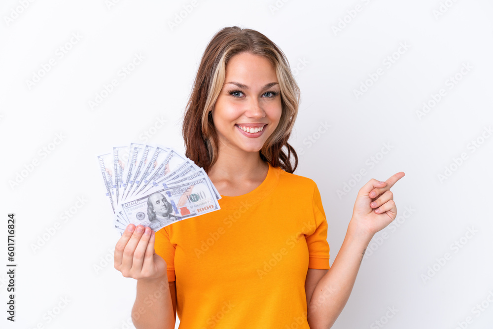Young Russian girl holding dollars isolated on white background pointing back Young Russian girl holding dollars isolated on white background pointing back