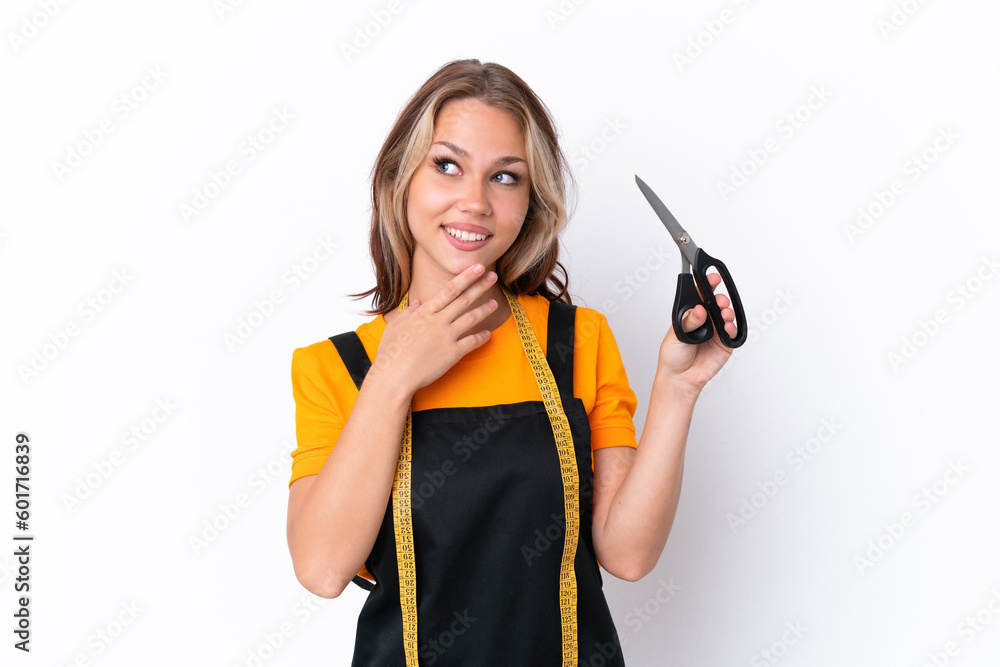 Young Russian seamstress girl isolated on white background looking up while smiling