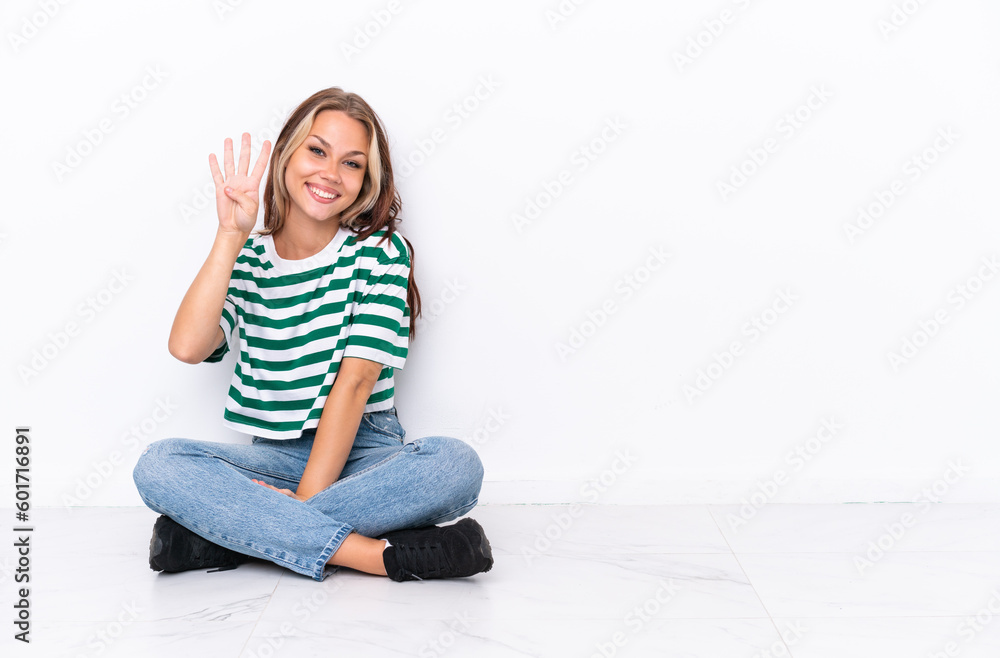 Young Russian girl sitting on the floor isolated on white background happy and counting four with fingers Young Russian girl sitting on the floor isolated on white background happy and counting four with fingers