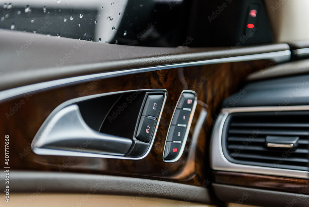 Car inside door chrome handle. Panel with seat settings driver's. Buttons to adjust driver's seat memory. Closeup car interior. Car door control left panel. Blocking opening and closing of doors.