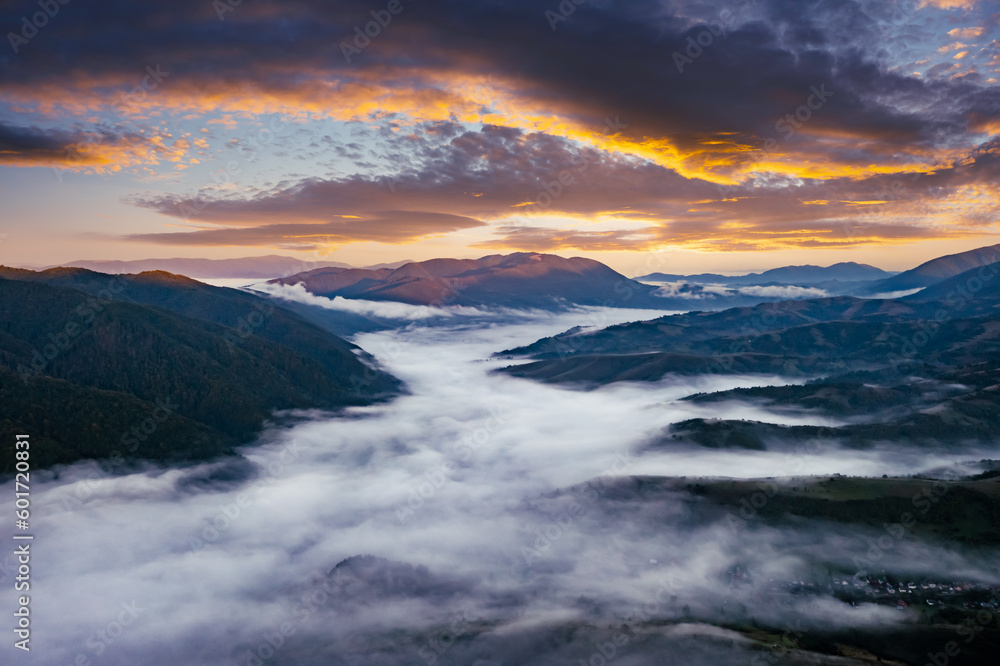 Amazing flowing morning fog in summer mountains. Beautiful sunrise on background. Landscape photography