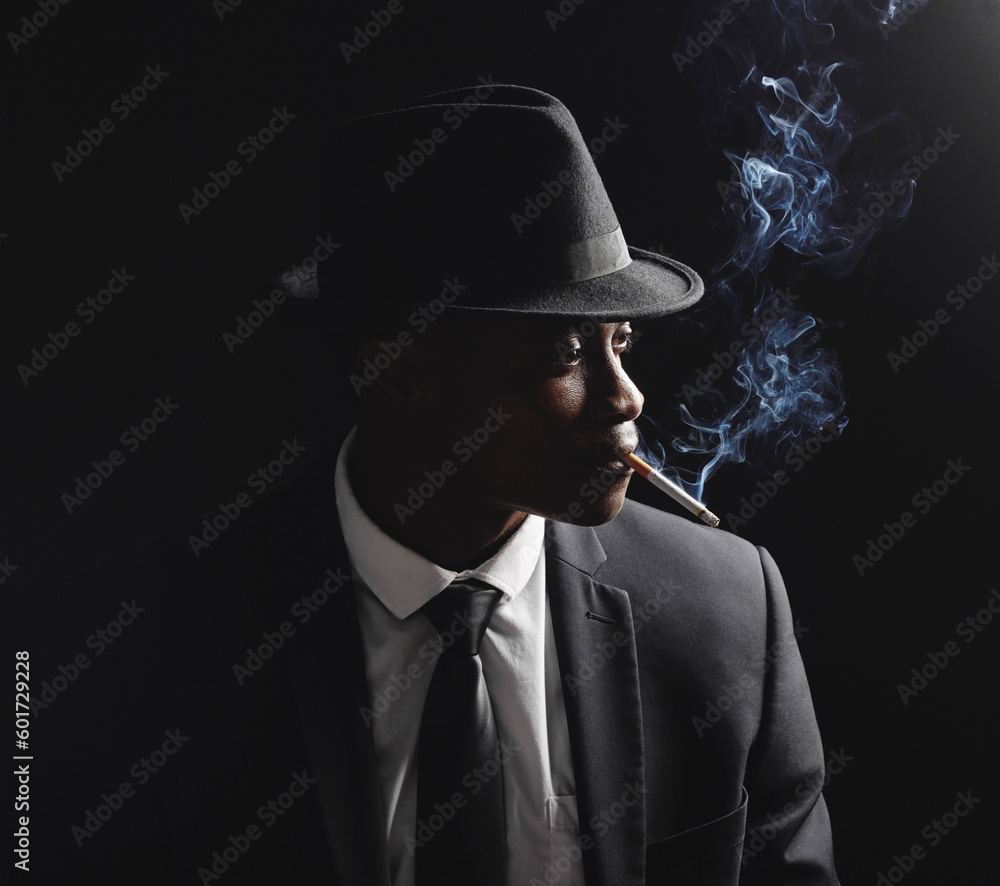 Man, gangster and cigarette in studio by dark background with smoke, silhouette and dangerous in shadow. Mafia, secret agent or male in night for smoking with vintage aesthetic by black backdrop Man, gangster and cigarette in studio by dark background with smoke, silhouette and dangerous in shadow. Mafia, secret agent or male in night for smoking with vintage aesthetic by black backdrop