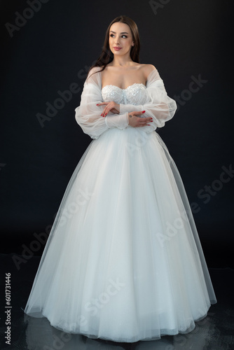 Perfect bride in wedding dress on black background