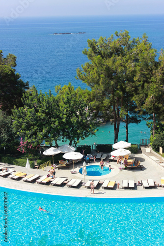 Travel destination, view on blue sea from balcony in Turkey with big water pool and pines. High quality vertical photo. photo