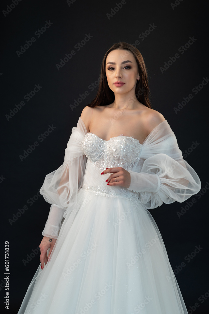 Perfect bride in wedding dress on black background