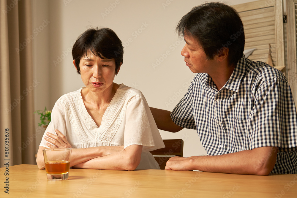 自宅で落ち込む中年女性 自宅で落ち込む中年女性