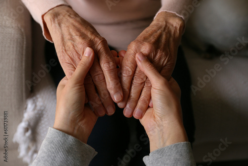 Leinwand Poster Cropped shot of elderly woman and female geriatric social worker holding hands