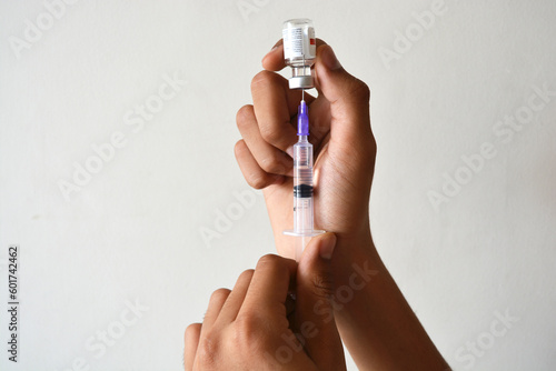 withdrawing of medicine from a vial using a needle and syringe
