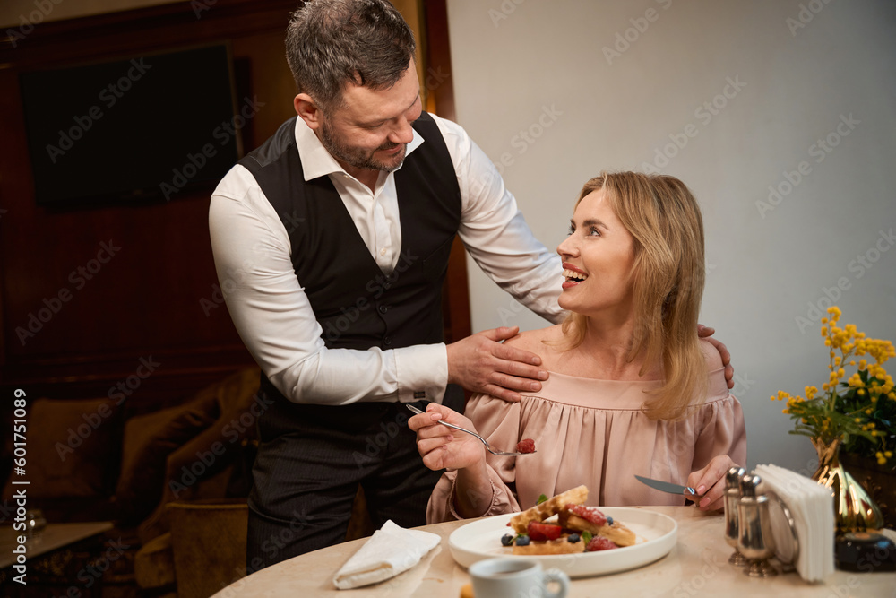 Man hugging his girlfriend by shoulders at restaurant Man hugging his girlfriend by shoulders at restaurant