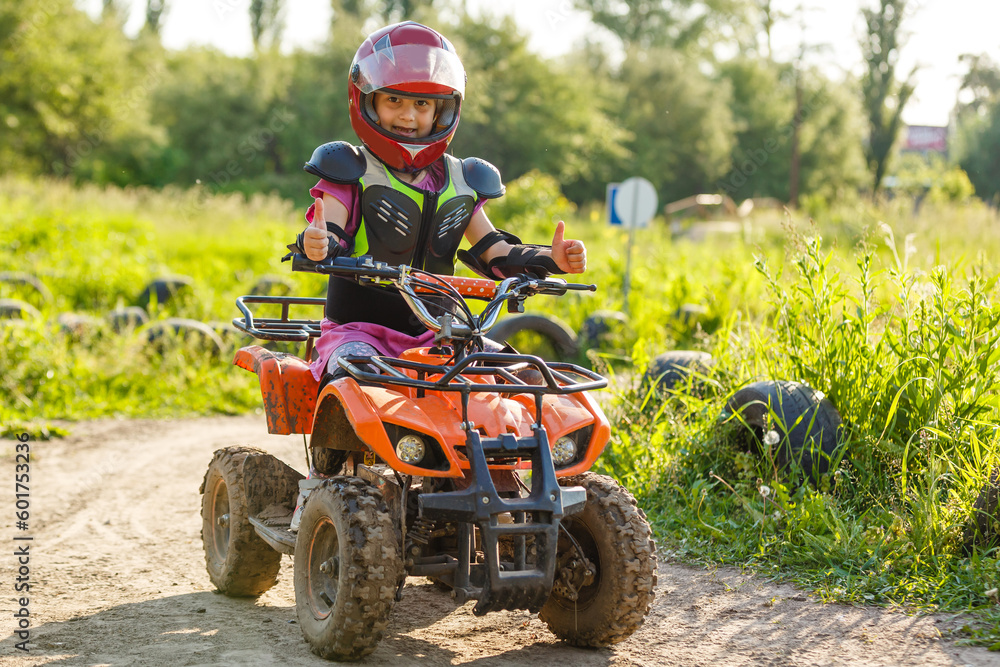 A child rides a quad bike through the mud. ATV rider rides A child rides a quad bike through the mud. ATV rider rides