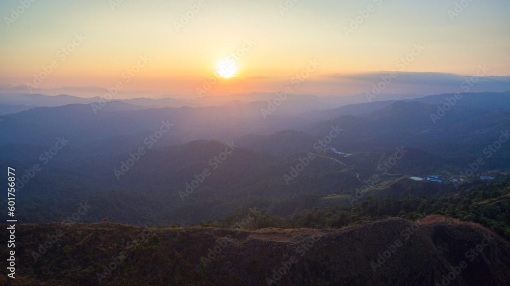 aerial view on the peak in sunset the village far from civilization Traveling on a difficult road..Beautiful sunset view on the hilltop complex..The sun shone through mountain peak after mountain.