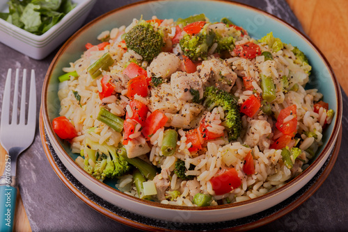 Chicken and vegetables with egg rice and garnished with herbs and seasoning.