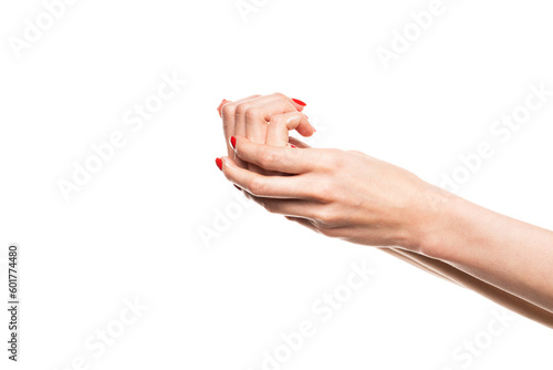 A girl smearing a handful of hand cream on her hand with red manicure. Photo isolated on white background.