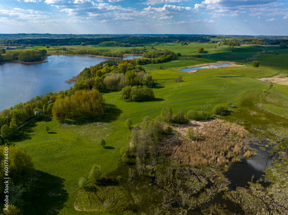 Beautiful drone nature landscape of fields, meadows, forest and lake - sunny day in Poland, Mazury aerial view