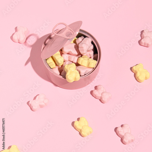 Pink tin can full of gummy bears, creative aesthetic layout, candy pink background.