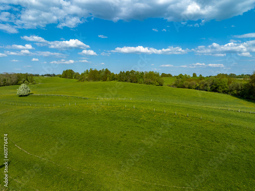 Aerial view of meadows and agricultural field in spring with blue sky, Poland, Mazury