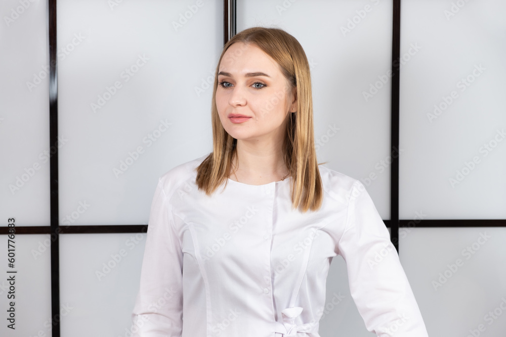 Portrait of a young blonde doctor in a white uniform on a black and white background. Portrait of a young blonde doctor in a white uniform on a black and white background.