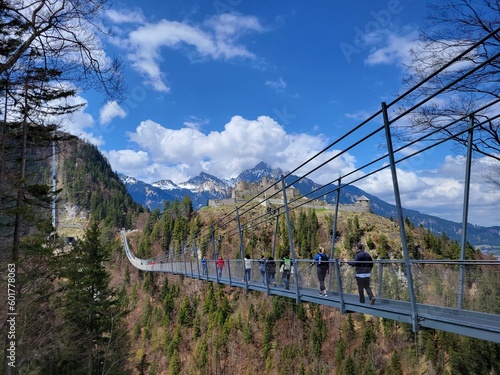 Long pedestrian swinging bridge across vast valley in the Alps of western Austria