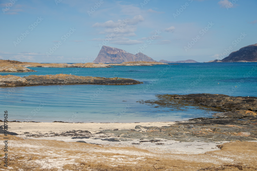 Calm bay with island and small light house in the back ground.