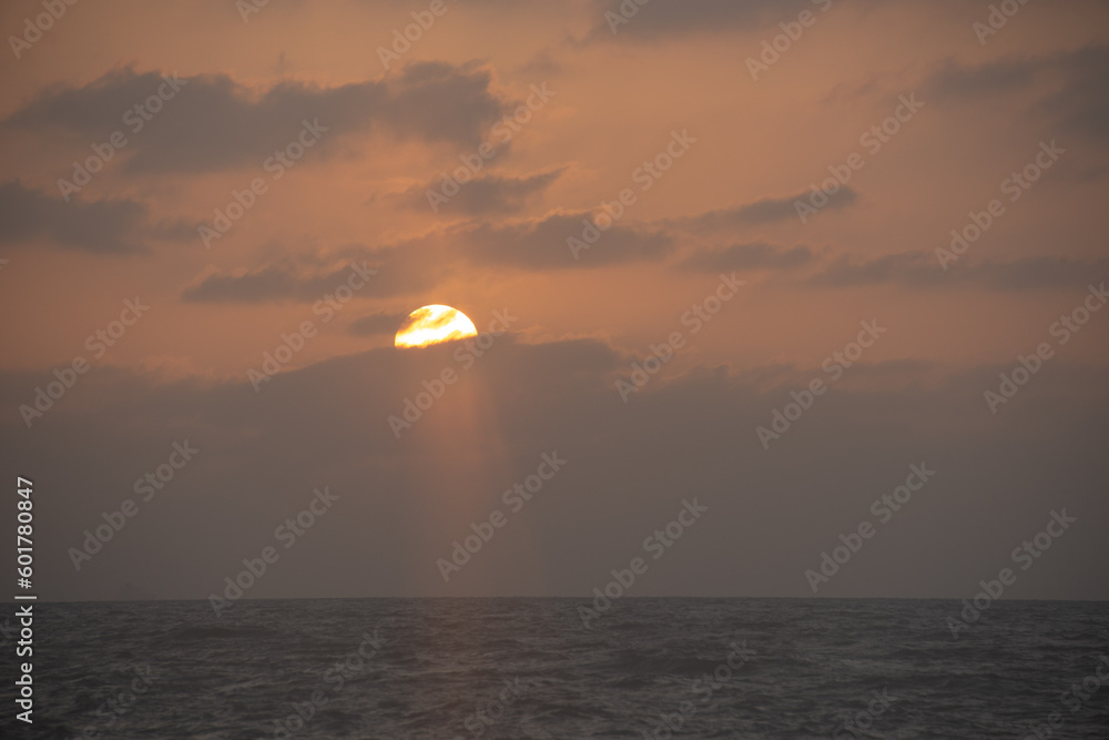 orange sunset over the see with a little fog and dramatic sun orange sunset over the see with a little fog and dramatic sun