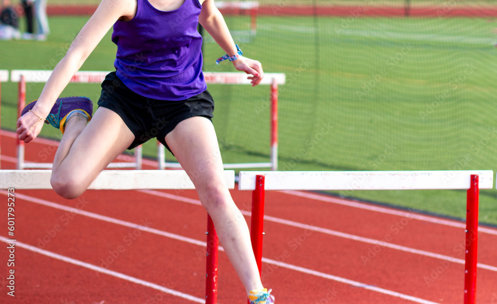One girl hurdling running over a hurdle during a race